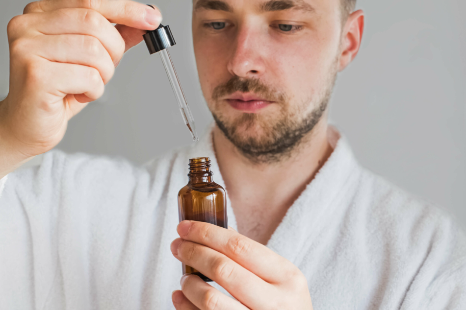 Man applying minoxidil with a dropper as part of a hair loss treatment routine